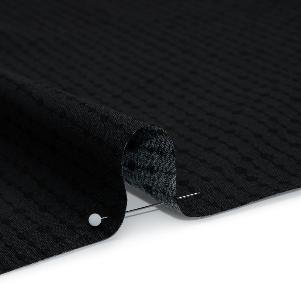 Close-up of black textured fabric  on a white surface