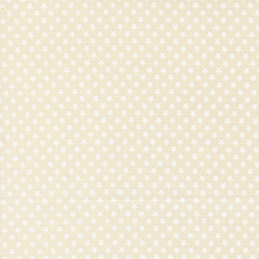 Cream colored fabric with many small white stars.