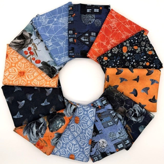 A circular arrangement of multiple folded fabric pieces in assorted Halloween-themed patterns, including spiderwebs, haunted houses, bats, pumpkins, and ghosts, shown on a plain white background.
