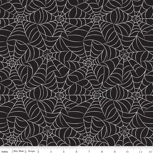 Pattern of spider webs on a black background with a ruler at the bottom.