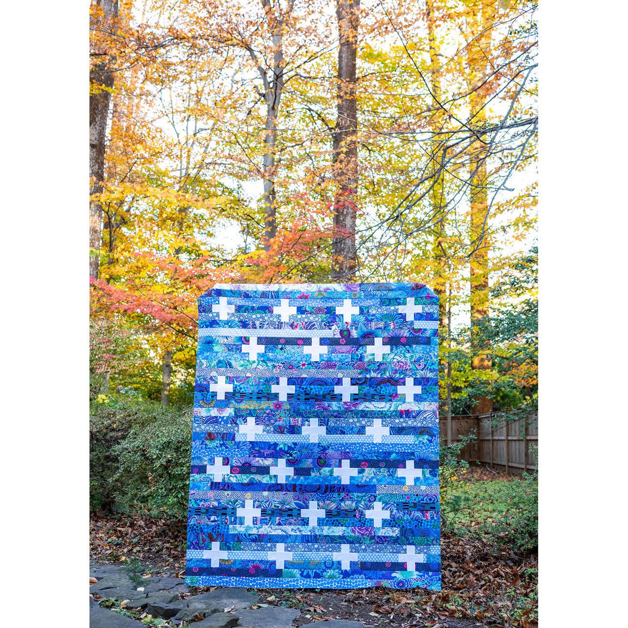 Jelly Plus finished quilt by Modernly Morgan — bright pink, teal, and yellow jelly roll strip quilt with white plus sign blocks
