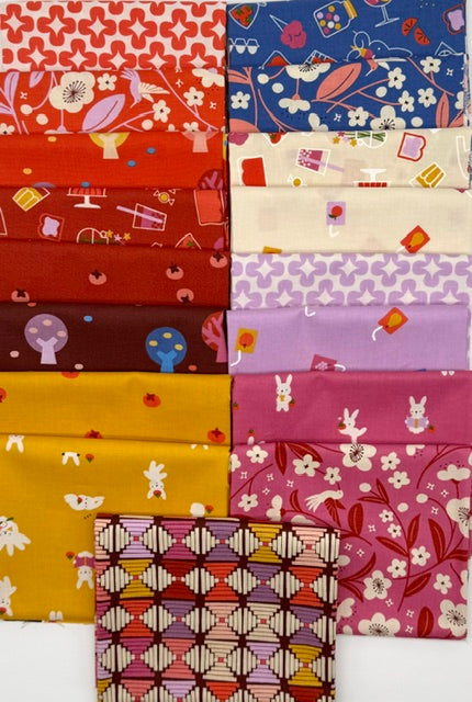 A rectangle arrangement of colorful patterned fabric swatches on a plain white background, showing multiple fabric colors and prints including red, yellow, pink, purple, blue, and cream with small illustrated motifs.