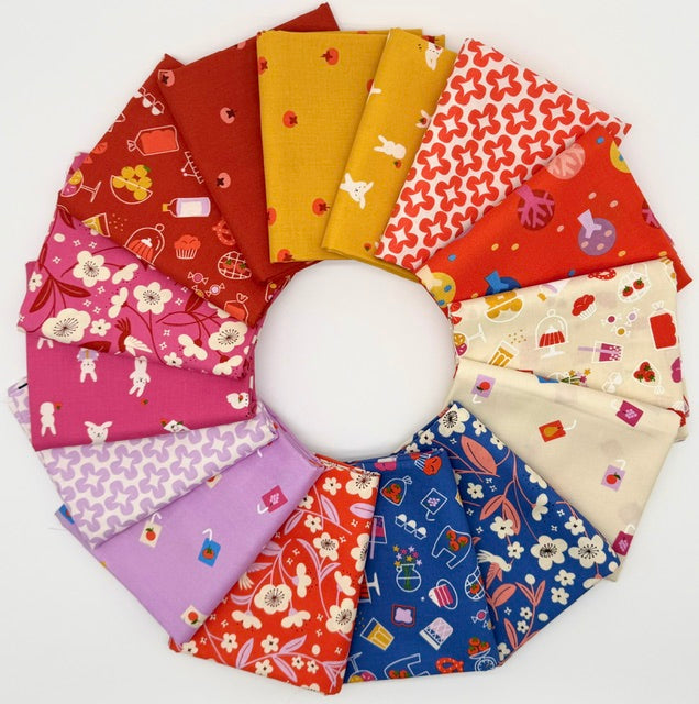 A circular arrangement of colorful patterned fabric swatches on a plain white background, showing multiple fabric colors and prints including red, yellow, pink, purple, blue, and cream with small illustrated motifs.