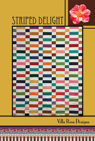 Striped Delight quilt pattern showing colorful horizontal strips in red orange green blue with pink flower accent corner detail
