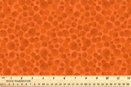 Orange fabric with circular patterns and a ruler at the bottom for scale.